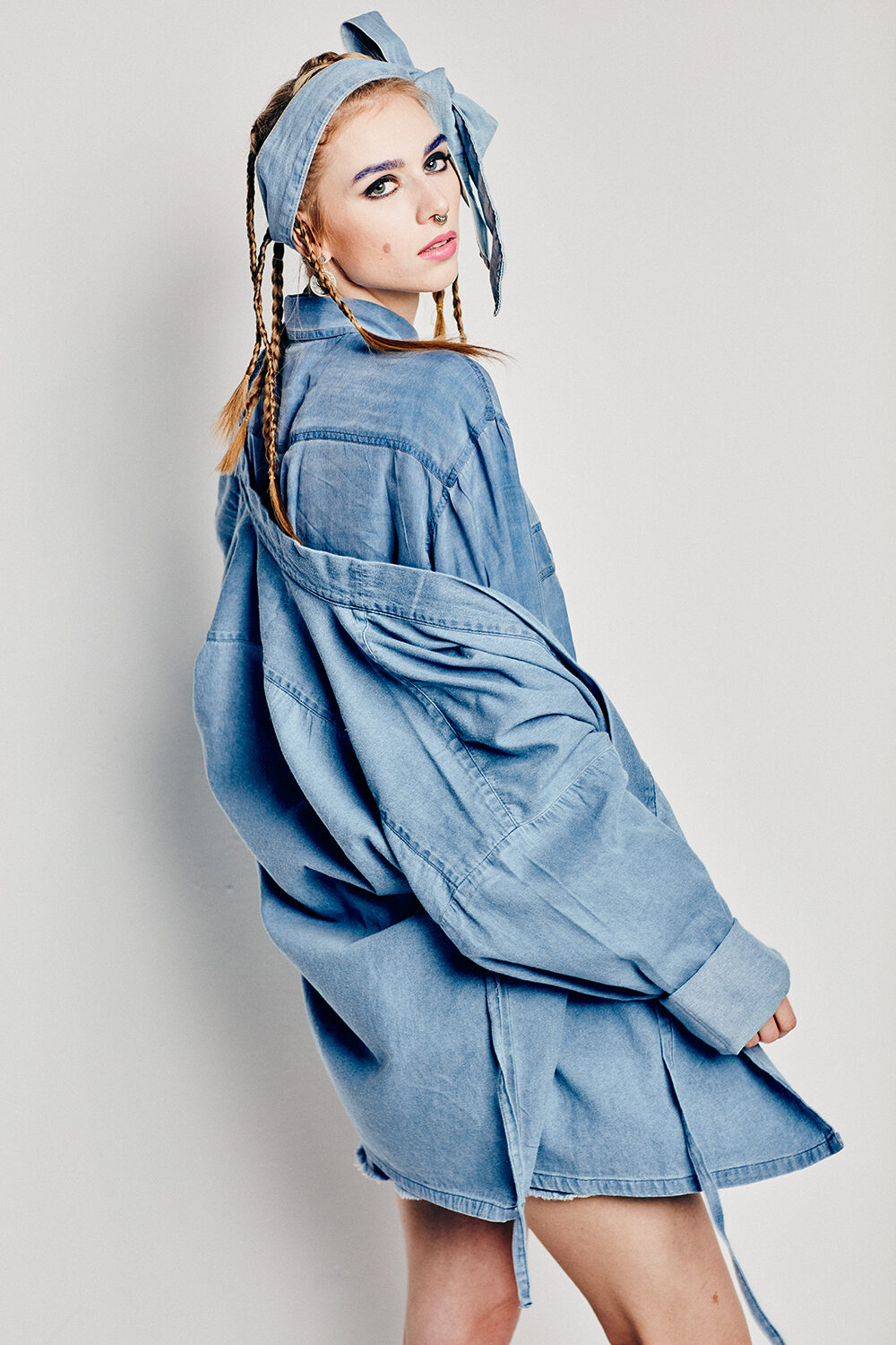 Denim-Editorial: Rückenansicht von Model Maria mit Denim-Haarband im Oversize-Jeanshemd.