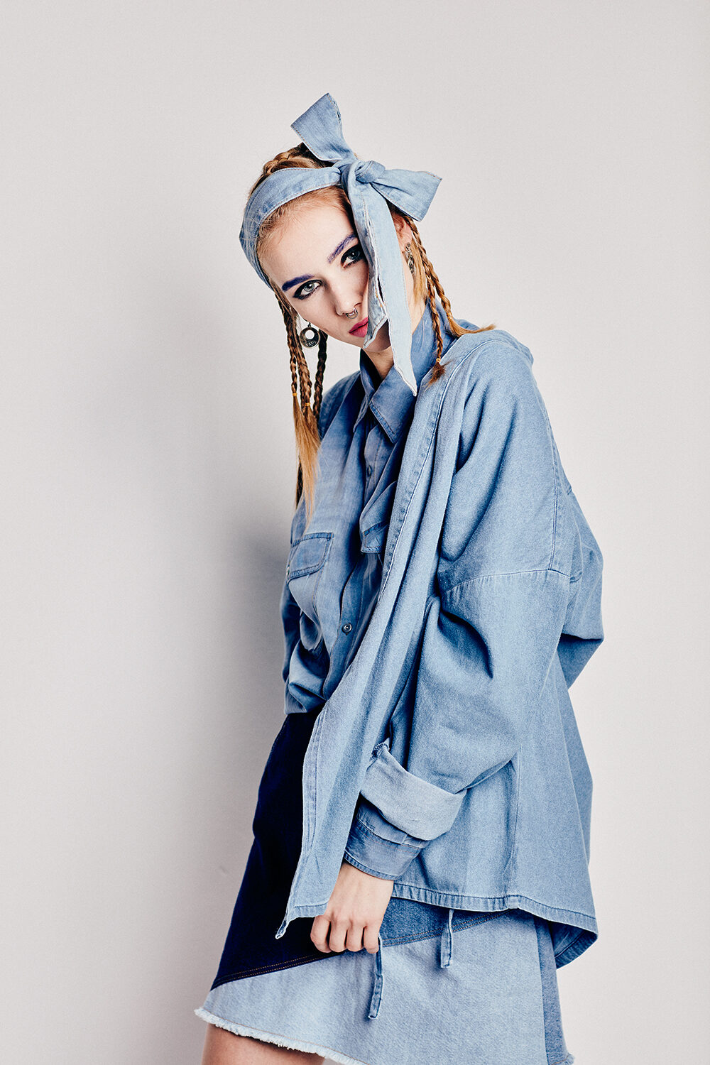Denim-Editorial: Model Maria mit Denim-Haarband und Zöpfen im Oversize-Jeanshemd über Jeansrock.
