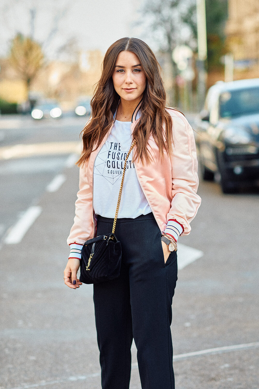 Streetstyle-Aufnahme der Fashion- und Lifestyle-Influencerin Janina Pfau in rosa Bomberjacke und S.Oliver-Shirt in Frankfurt am Main.