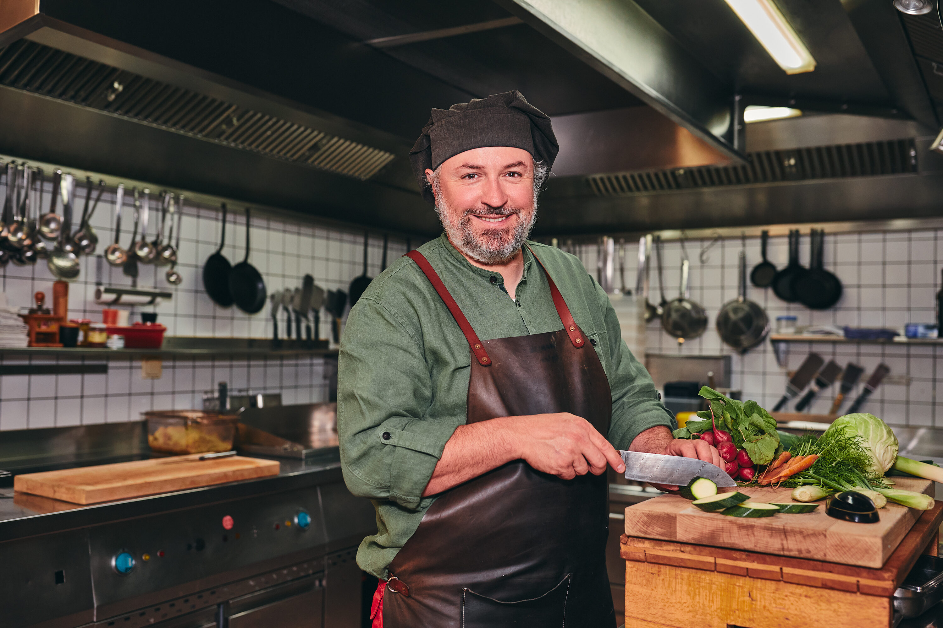Haubenkoch Jeremias Riezler schneidet in der Küche seines Restaurants in Riezlern frisches Gemüse für die alpine Küche.